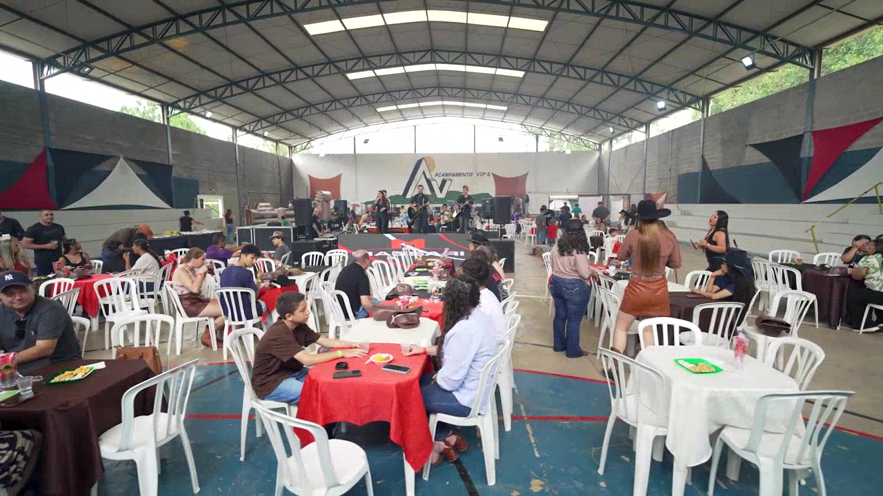Decoração elegante de evento ao ar livre sob árvores com iluminação